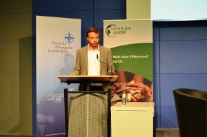 Gregor Hofmann, stellvertretender Vorsitzender von Genocide Alert begrüßt die Besucher zur Diskussion "Zwanzig Jahre Srebrenica - Folgen und Lehren für die internationale Staatengemeinschaft"; Quelle: eigenes Foto.