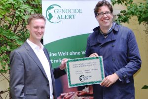 Der Vorsitzende von Genocide Alert Dr. Robert Schütte übergibt das Menschenrechtszeugnis mit der Note „1, sehr gut“ an den Bundesgeschäftsführer der Grünen Michael Kellner in der Bundesgeschäftsstelle der Grünen in Berlin, 19. September 2017 (© Genocide Alert)